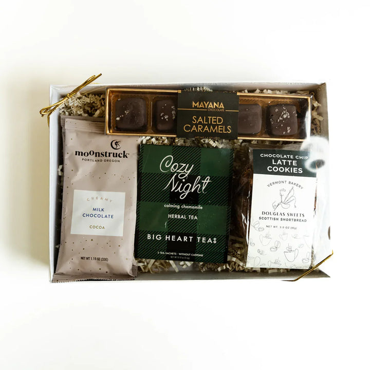 Gift box containing chocolate, tea, and cookies on a white background