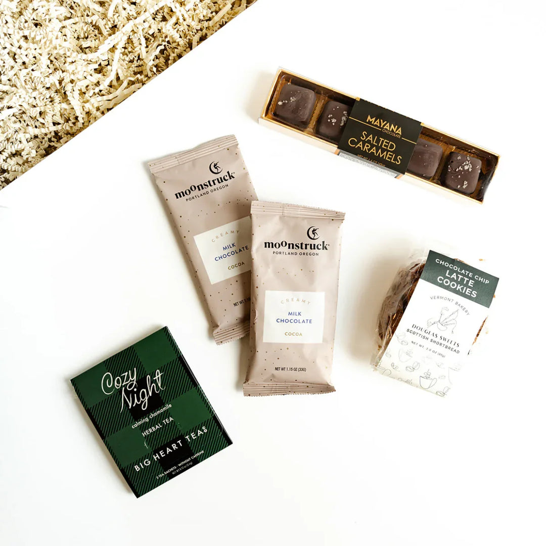 Assorted moonstruck chocolate bars and tea packages on a white surface.