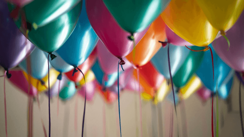 Colorful helium balloons with ribbons, festive decoration for birthday or celebration event