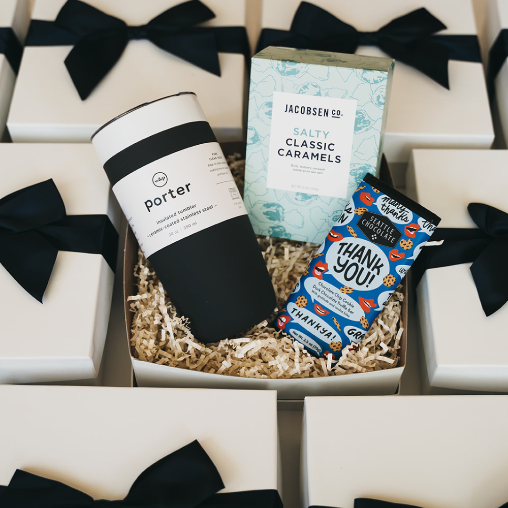Gift box with insulated tumbler, salty caramels, chocolate bar, white box and black ribbon