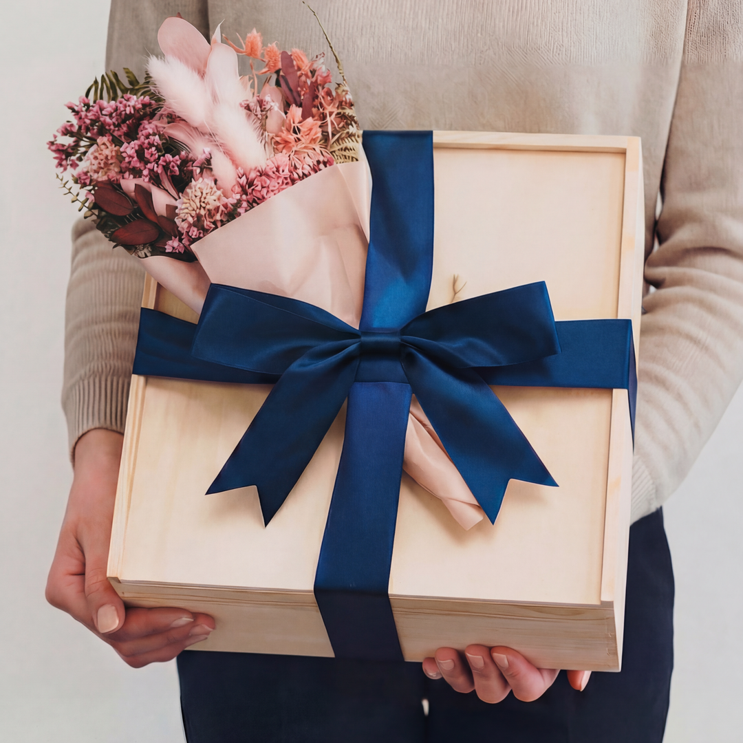 Wooden gift box with navy ribbon and pink dried flower bouquet