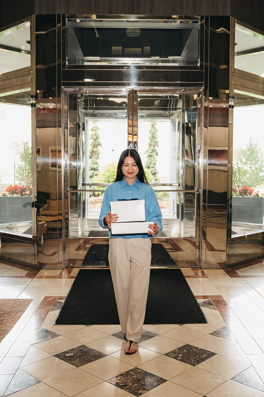 Carrying stacked Giften Market gift boxes through an office lobby