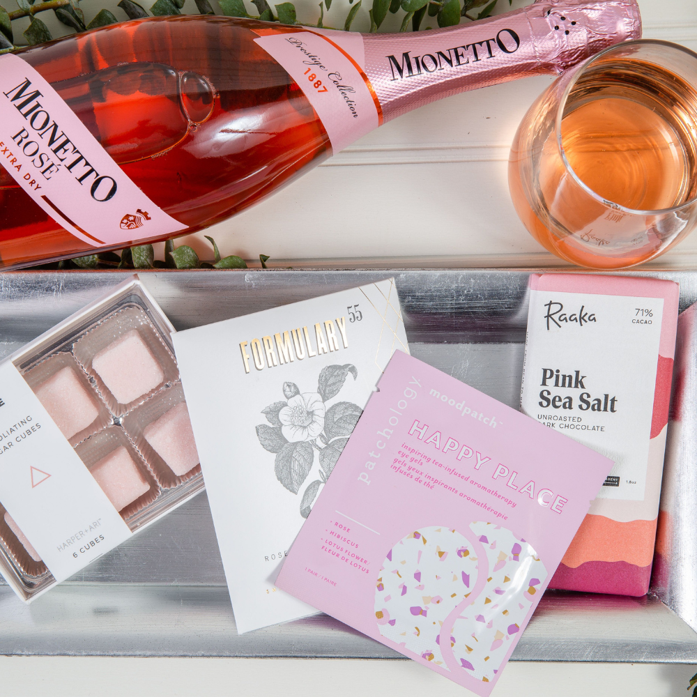Gift box with rosé wine, pink sea salt chocolate, sugar cubes, face mask, and bath soak