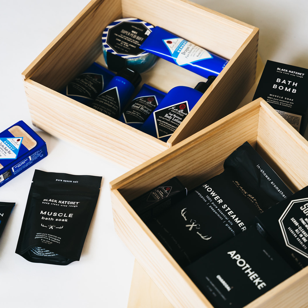 Wooden gift boxes with body lotion, soap bar, bath soak, and grooming essentials