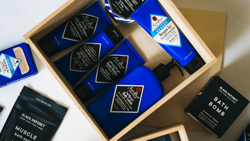 Wooden gift box with blue skincare bottles, bath soap bar, muscle bath soak, and bath bomb
