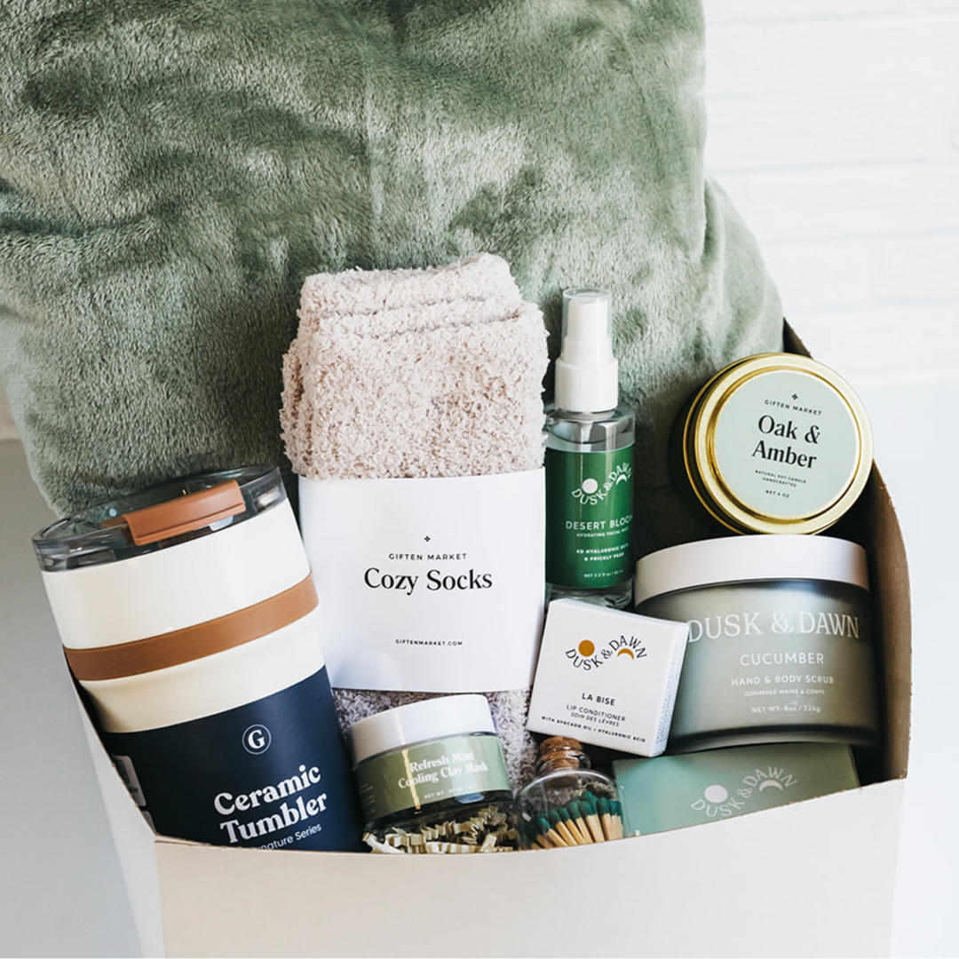 Sage green comfort gift box with cozy socks, ceramic tumbler, body care, and candle.