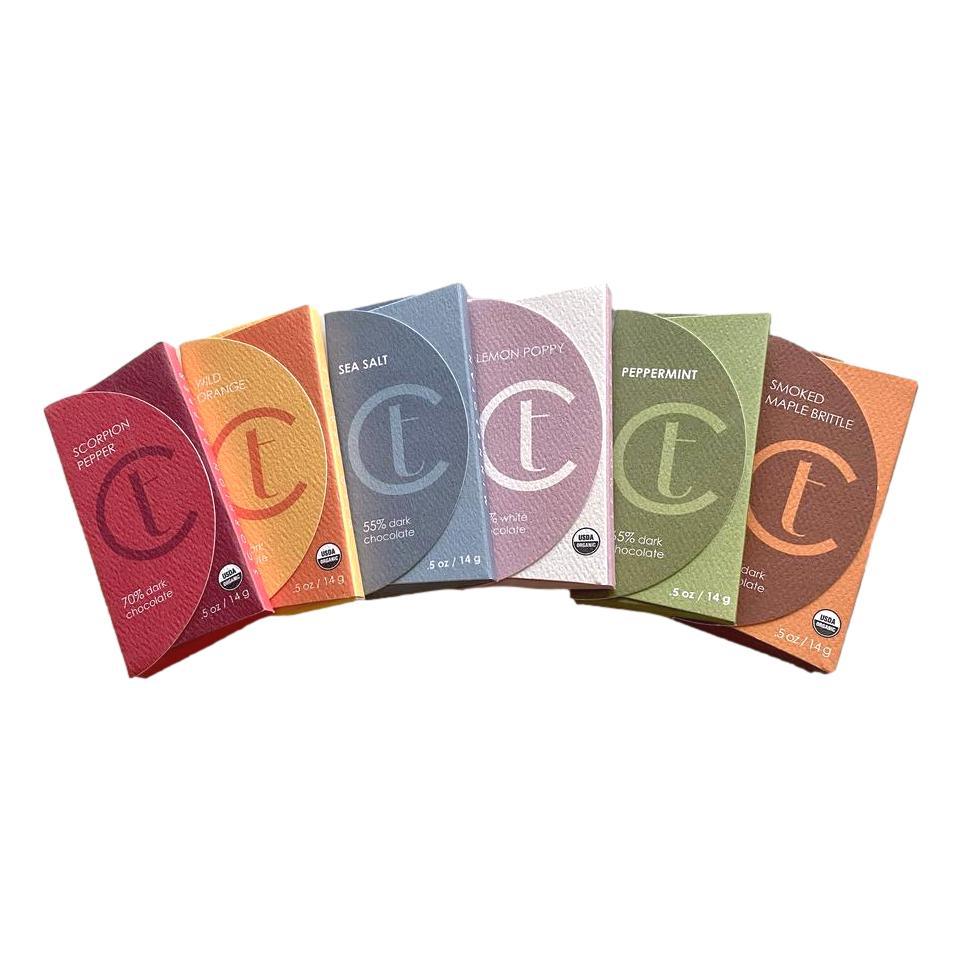 Assorted artisan chocolate bars with colorful packaging arranged in a fan display