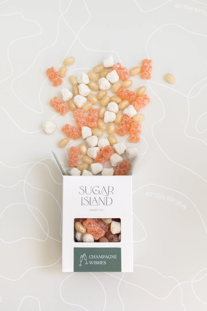 Open Champagne Wishes box with pink and white candies spilling out the top