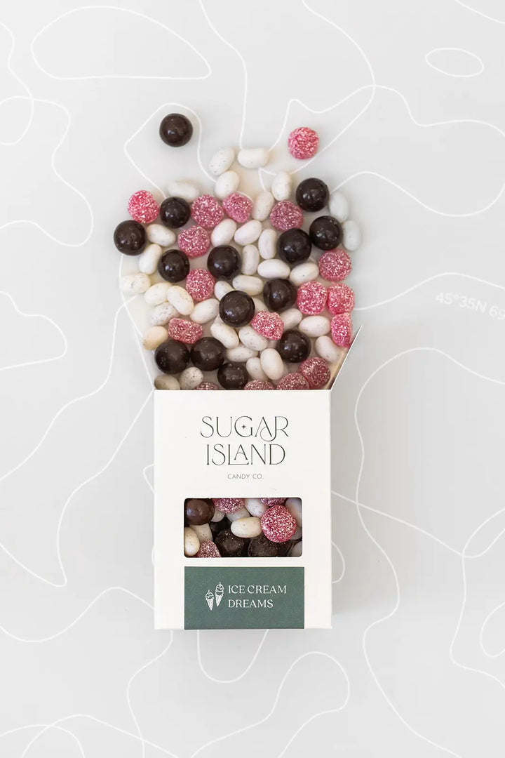 Open Ice Cream Dreams box with chocolate caramels and pink and white candies spilling out the top