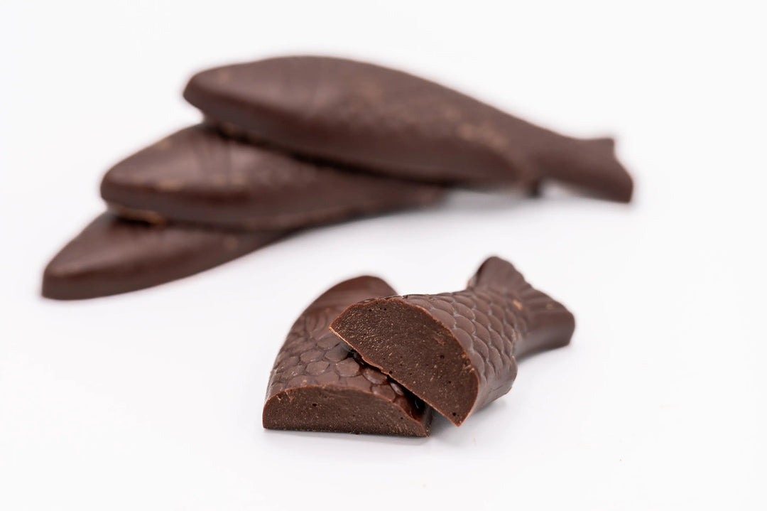 Close view of dark chocolate fish, one broken to show the solid chocolate inside