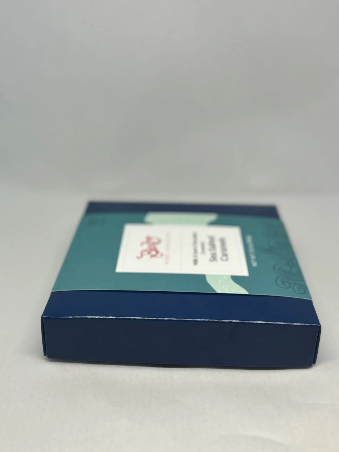 Blue Bixby caramels gift box with a teal sleeve, shown from the side
