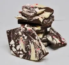 Stacked pieces of dark and white chocolate peppermint bark topped with crushed candy cane