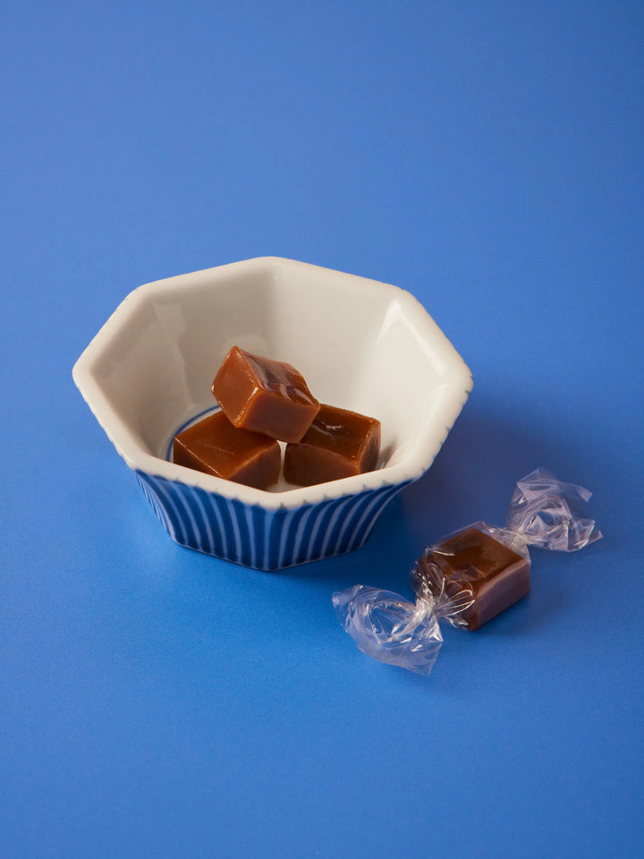 Earl Grey caramels in a blue and white bowl with wrapped caramels beside it