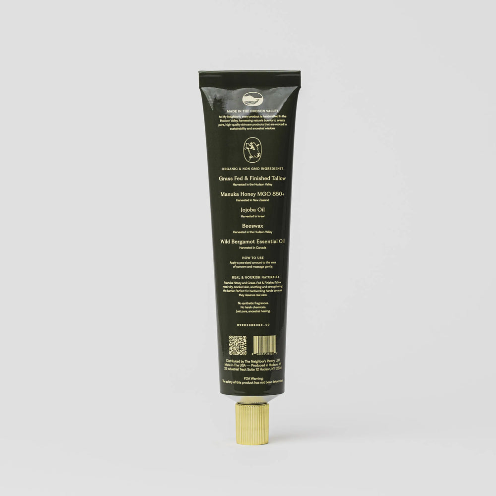 Back of the black hand balm tube showing the ingredient panel and barcode