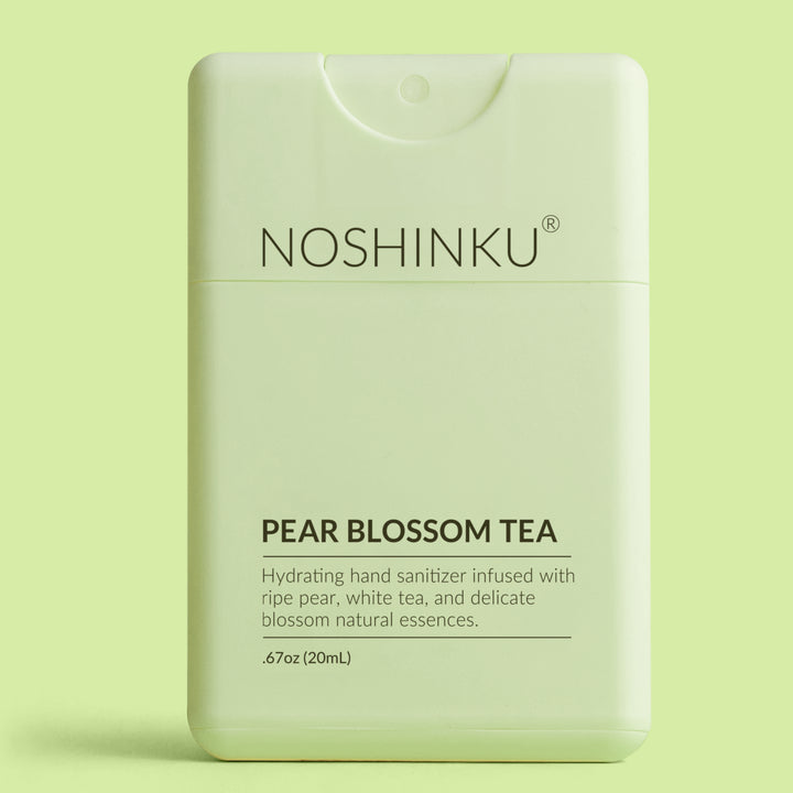 Pale green Noshinku Pear Blossom Tea pocket hand sanitizer on a light green background