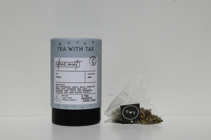 Light blue Alpine Mint mini tea tube beside a pyramid tea sachet and loose tea