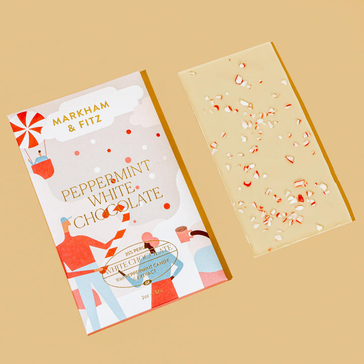 Peppermint White Chocolate sleeve laid next to the white chocolate bar topped with crushed peppermint candy