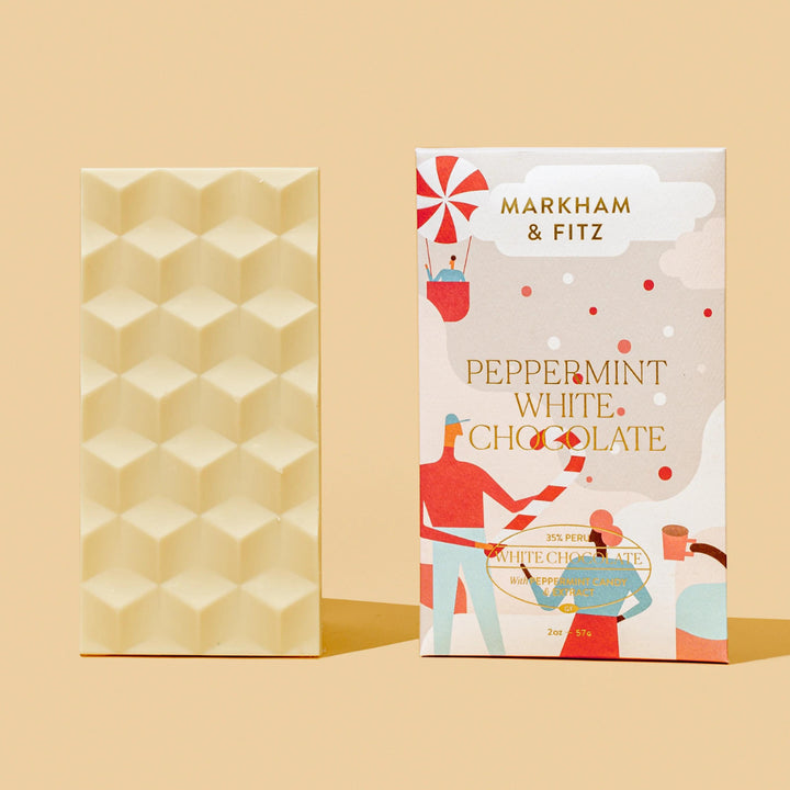 Back of the white chocolate bar showing its faceted mold, standing beside the Peppermint White Chocolate sleeve