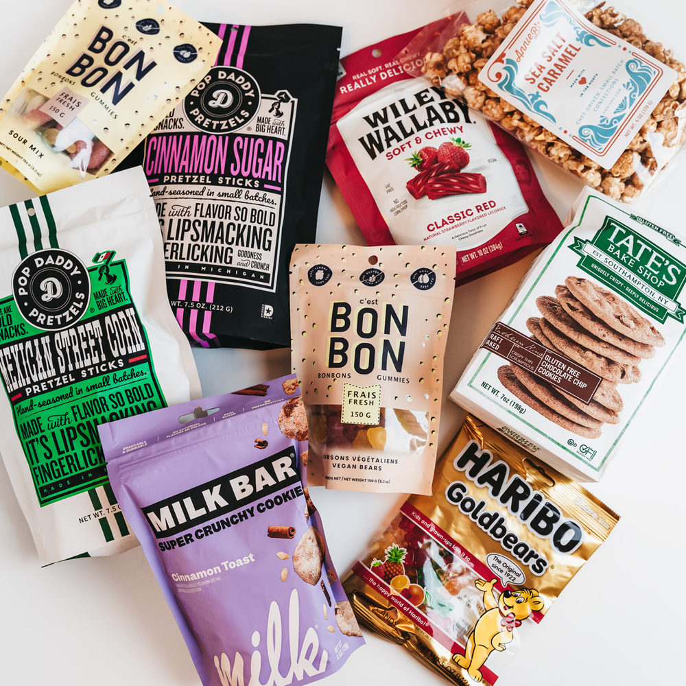 Assorted snack packages including Tate's, Haribo, and Milk Bar on a white background