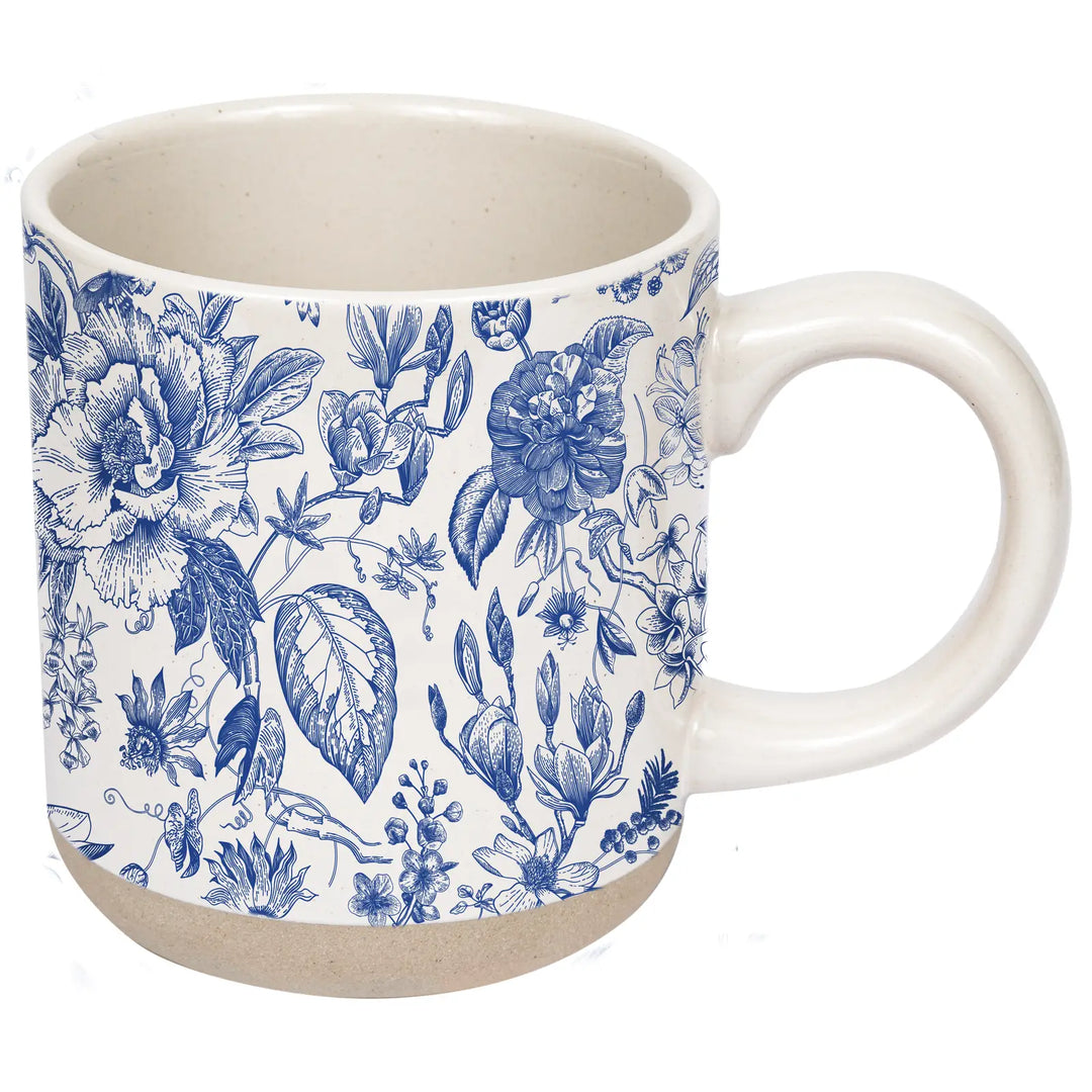 Side view of the cream and blue floral stoneware mug, showing the handle and the speckled base.