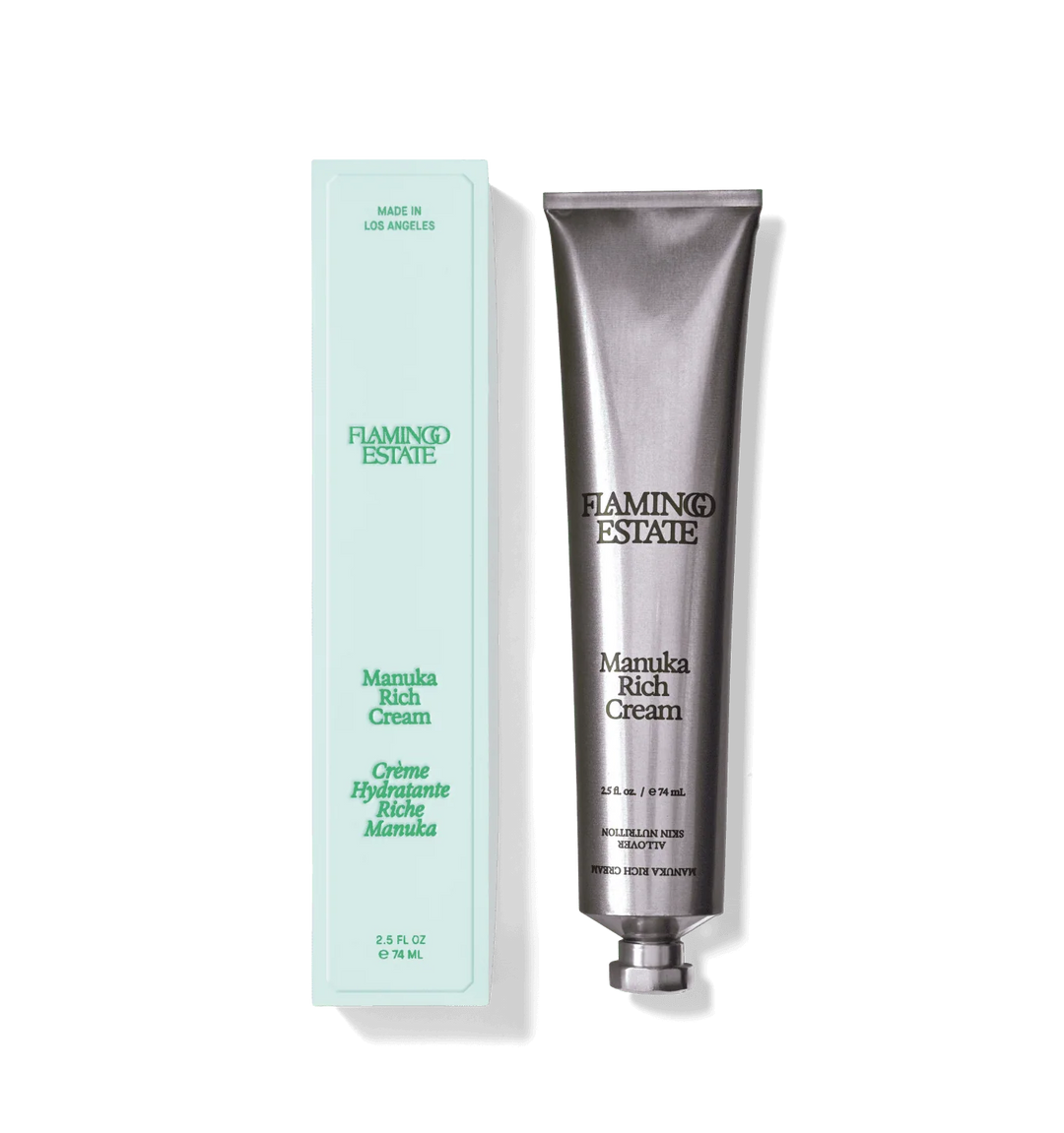 Silver aluminum tube of Manuka Honey Rich Cream beside its pale mint green carton on a white background