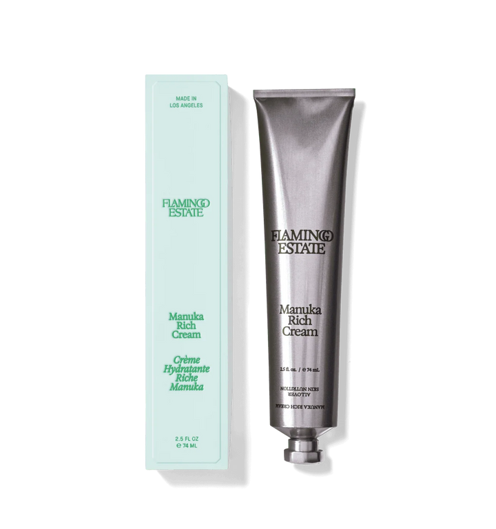 Silver aluminum tube of Manuka Honey Rich Cream beside its pale mint green carton on a white background