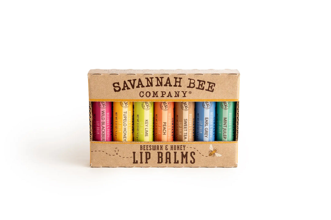 Savannah Bee Company beeswax and honey lip balm set in a kraft box, with seven colorful balms visible through the window
