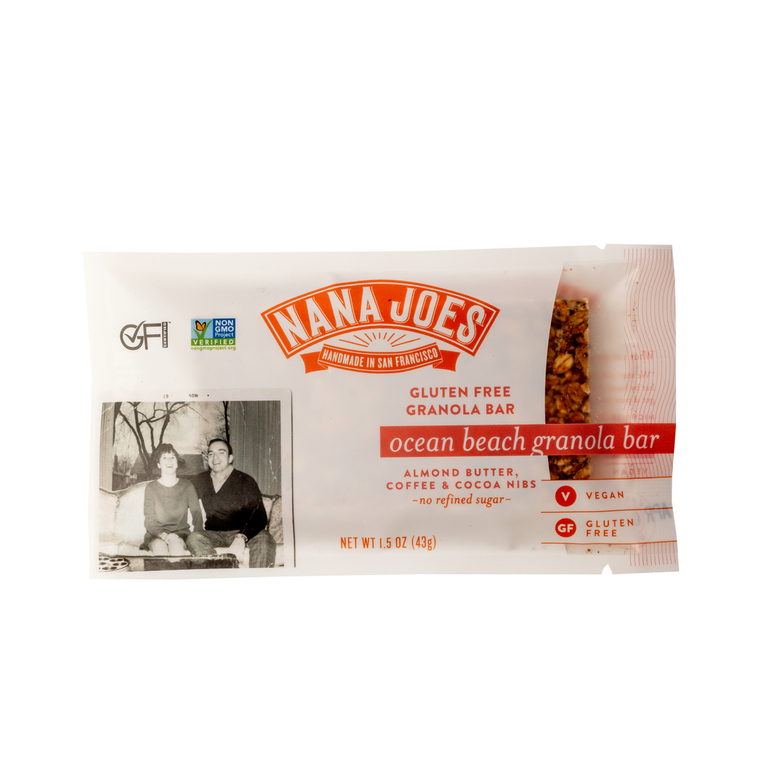Nana Joes Ocean Beach granola bar in a clear wrapper labeled almond butter, coffee and cocoa nibs, with a vintage family photo