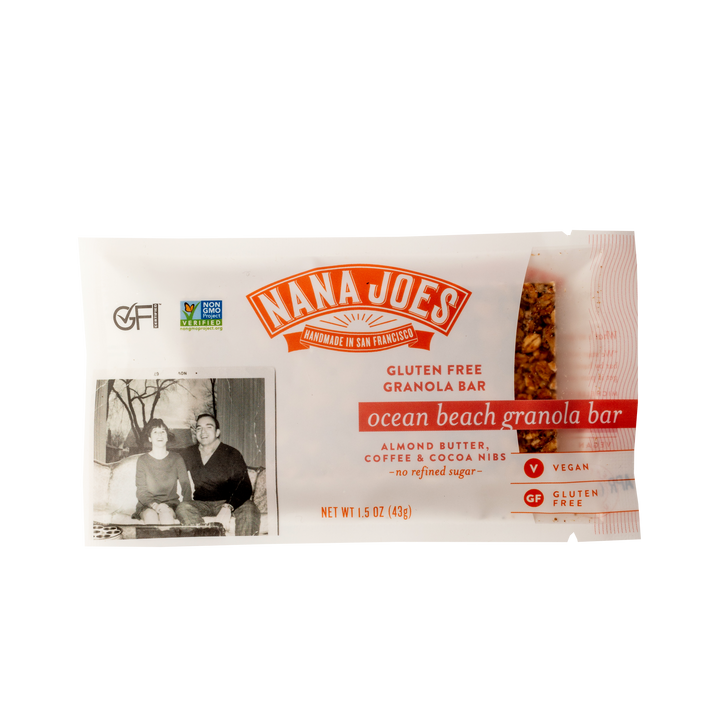 Nana Joes Ocean Beach granola bar in a clear wrapper labeled almond butter, coffee and cocoa nibs, with a vintage family photo