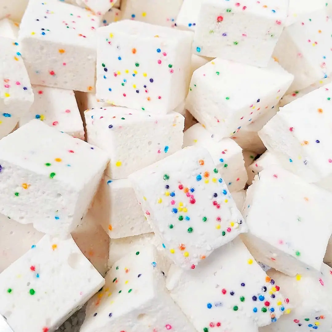 Pile of square white marshmallows dotted with rainbow sprinkles