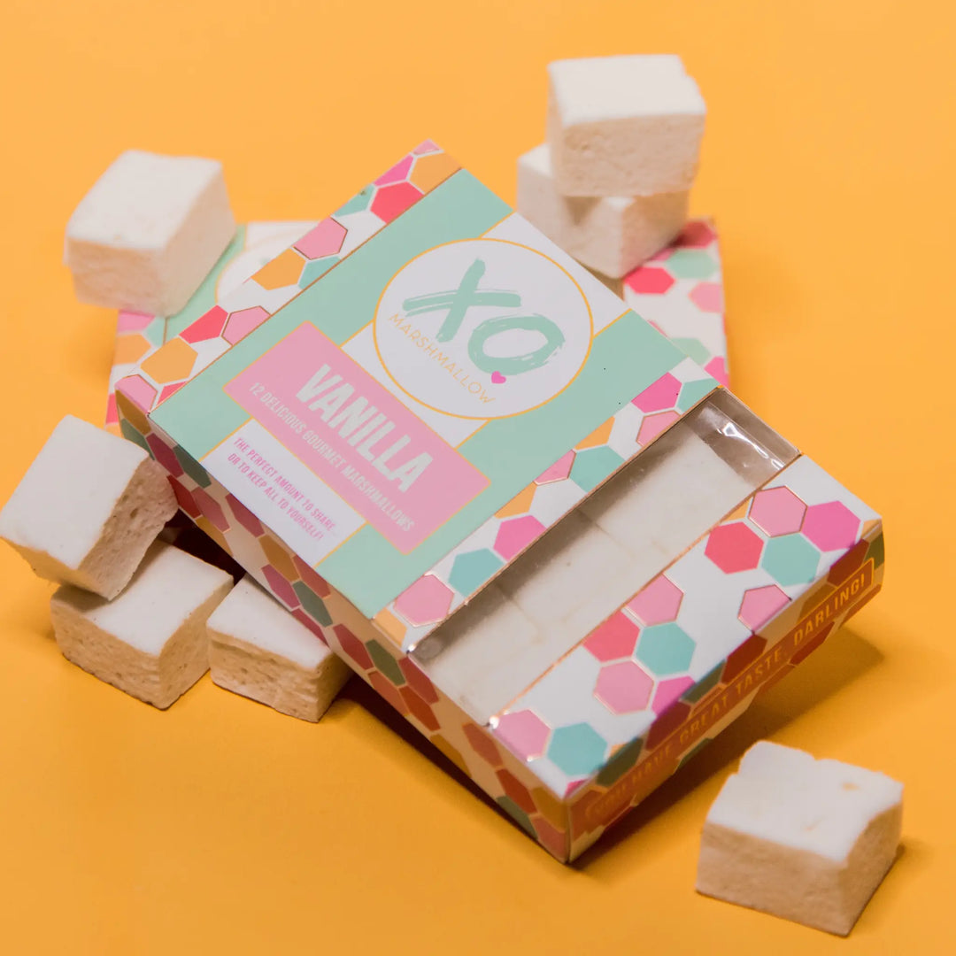 XO Vanilla marshmallow box with its window showing the marshmallows inside, loose cubes around it