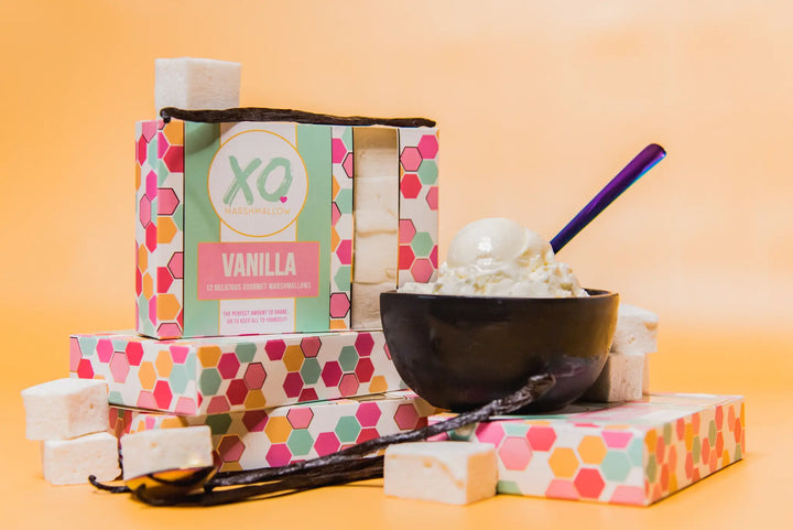 XO Vanilla marshmallow boxes beside a bowl of ice cream topped with marshmallows