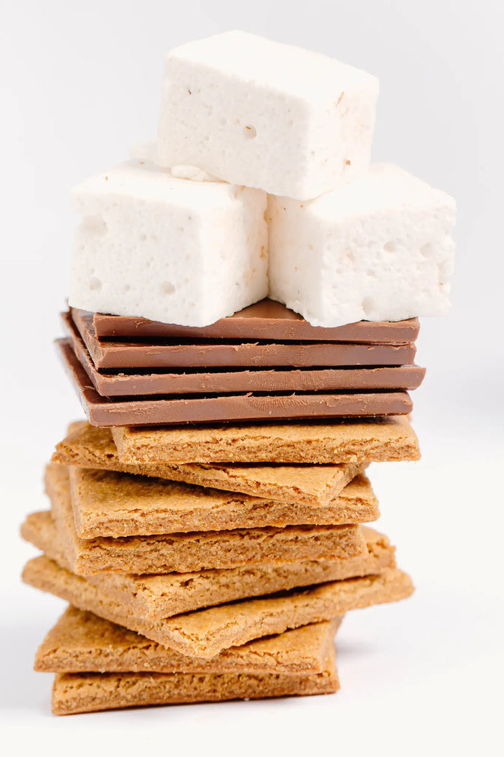 Tall stack of graham crackers, chocolate squares and marshmallows on a white background