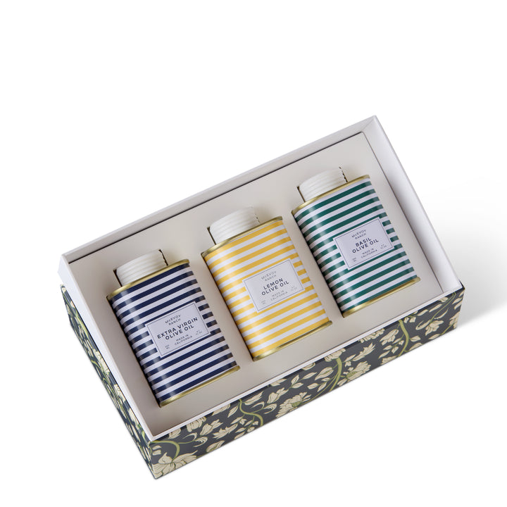 Open McEvoy Ranch gift box with the three striped olive oil tins seated in a white tray
