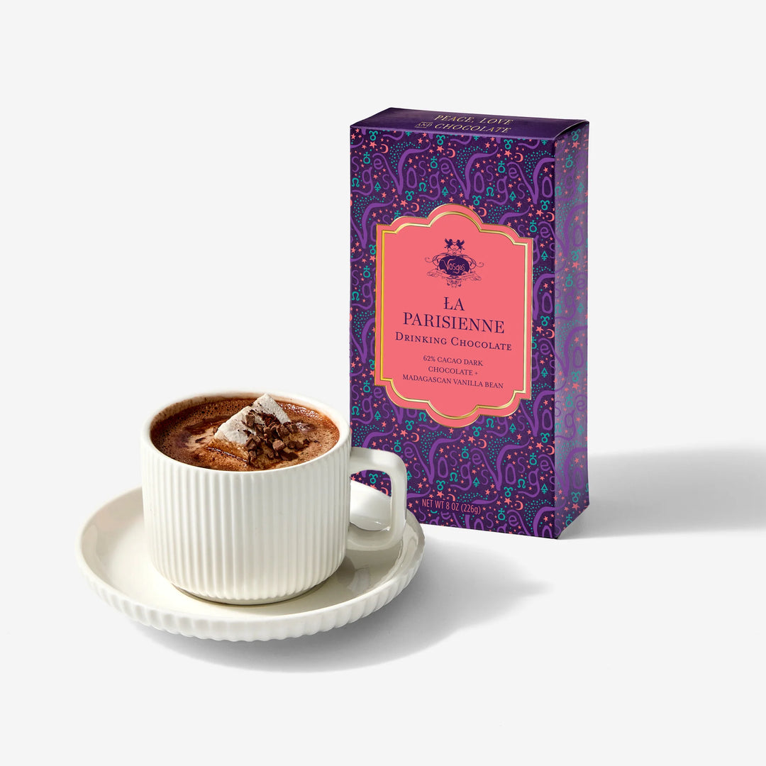Purple and coral La Parisienne drinking chocolate carton beside a cup of hot chocolate topped with a marshmallow