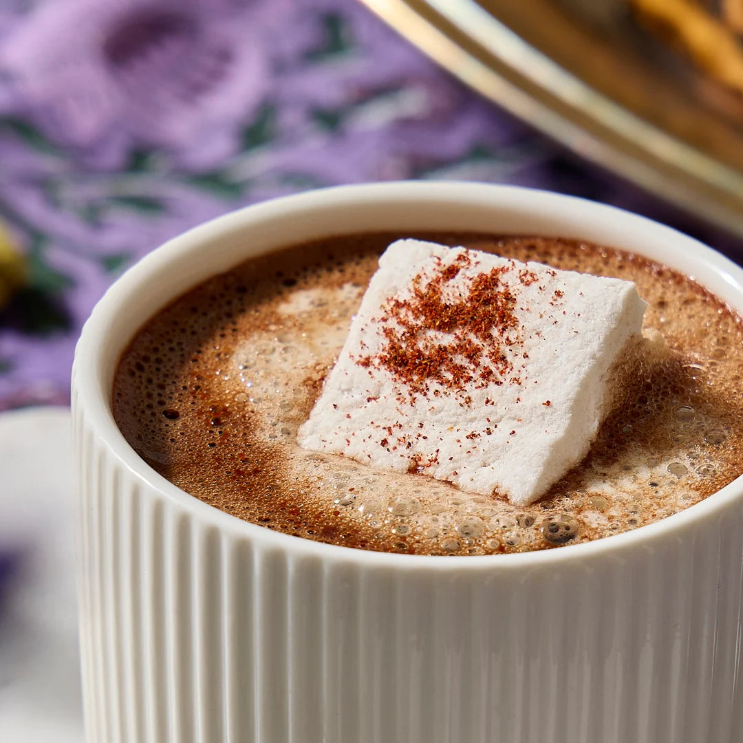 White vanilla marshmallow dusted with cocoa, melting on a mug of hot chocolate