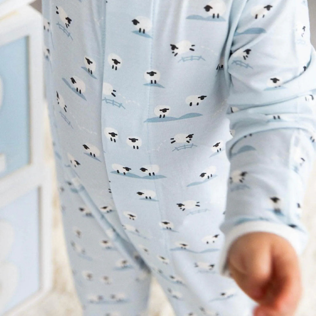 Close-up of baby wearing light blue magnetic footie pajamas with sheep print