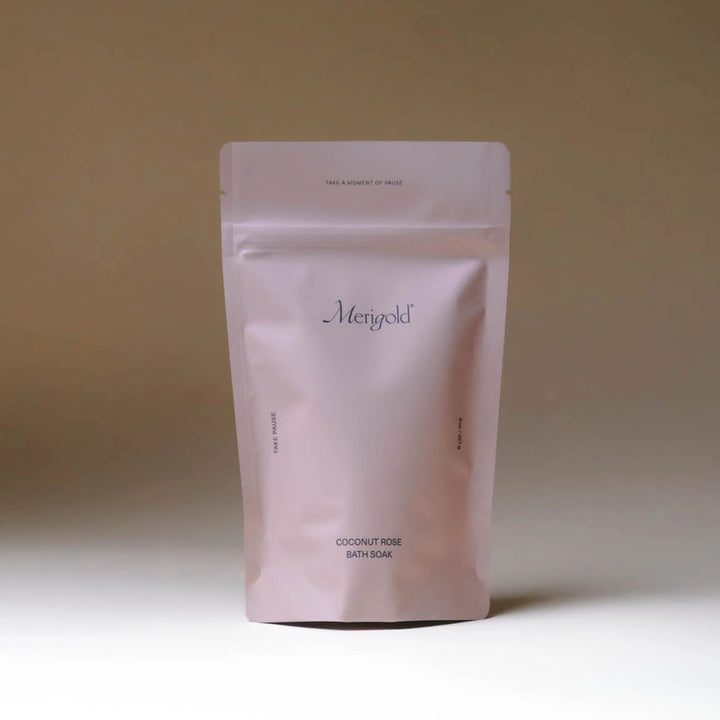 Resealable pouch of coconut rose bath soak with minimalist packaging on neutral background