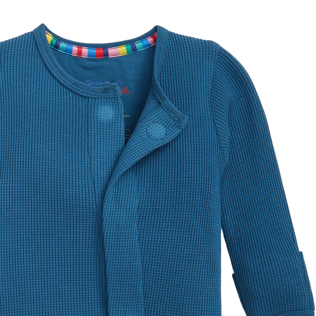 Dark blue waffle-knit baby footie sleeper with rainbow collar trim, partially unbuttoned.