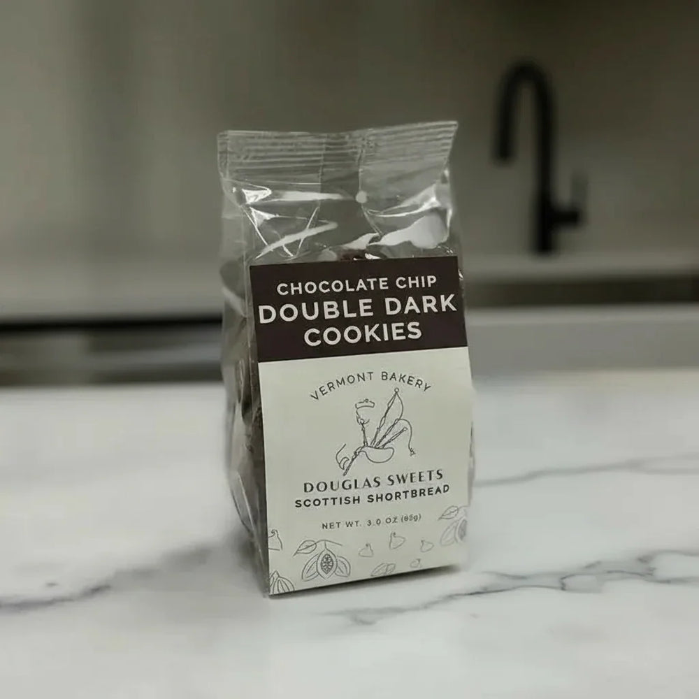 Packaged cookies with Vermont Bakery branding on a marble countertop.