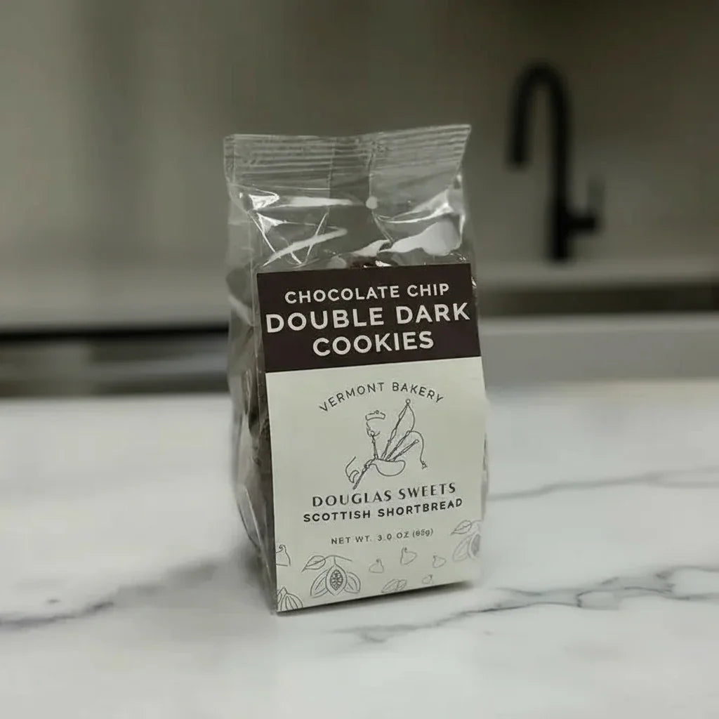 Packaged cookies with Vermont Bakery branding on a marble countertop.
