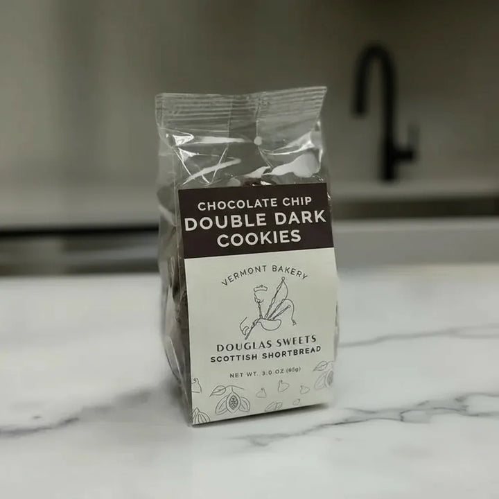 Packaged cookies with Vermont Bakery branding on a marble countertop.
