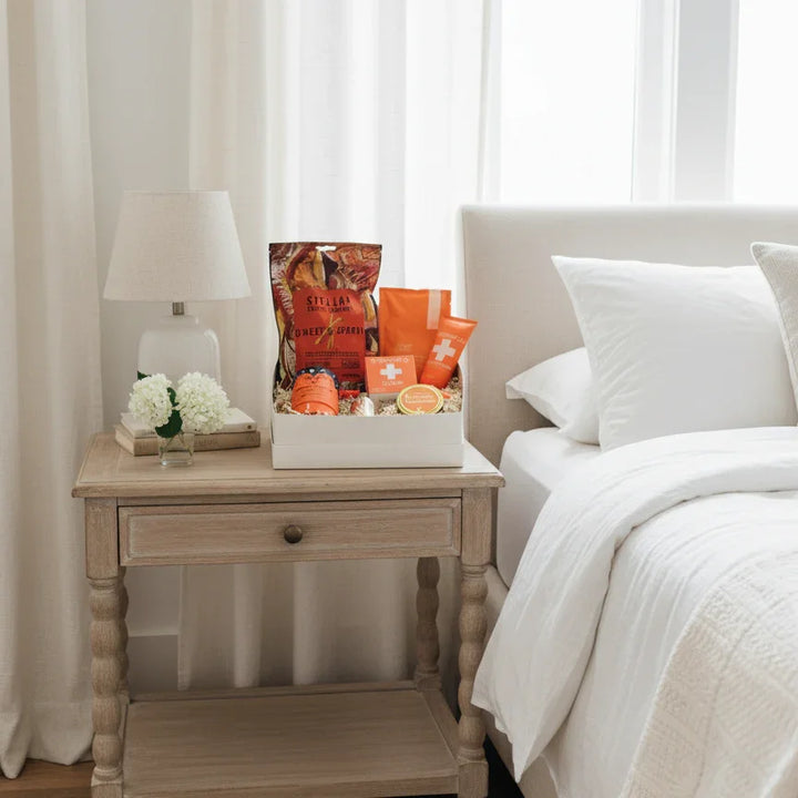 Bedroom with a nightstand and decorative items, including a box of oranges and a lamp.