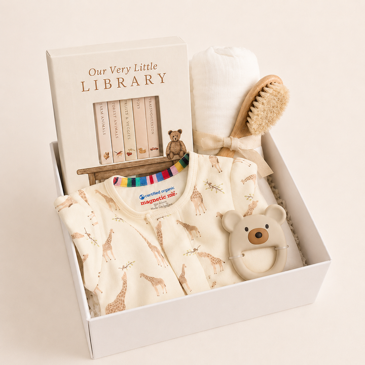 Sweet Beginnings Baby Gift Box in Jolie Giraffe: cream giraffe-print footie, Our Very Little Library, cream swaddle, wooden brush and bear teether