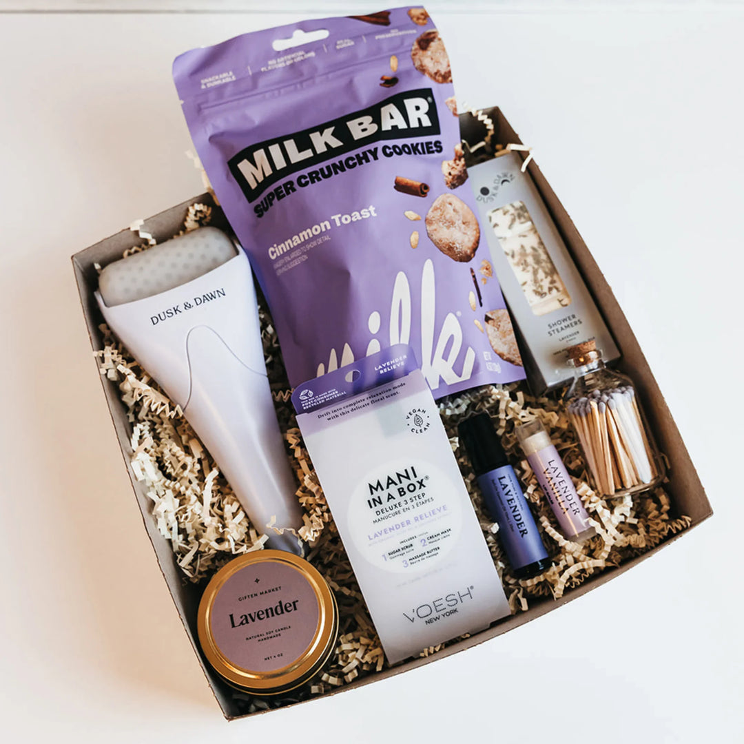 Unwind Ritual Gift Box with lavender candle, shower steamers, ice roller, and spa essentials.