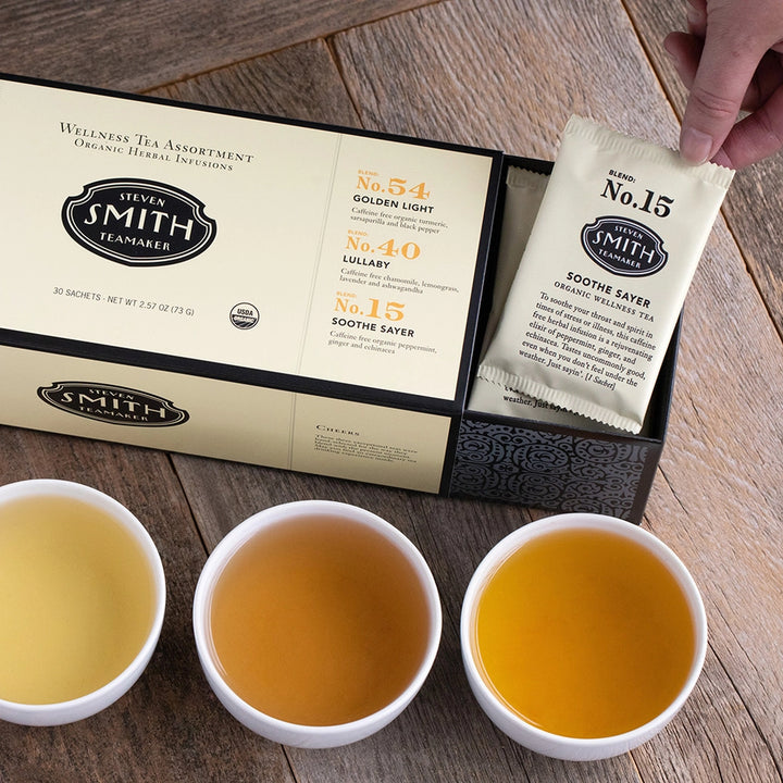 Wellness tea assortment gift box with three varieties and brewed tea in white cups