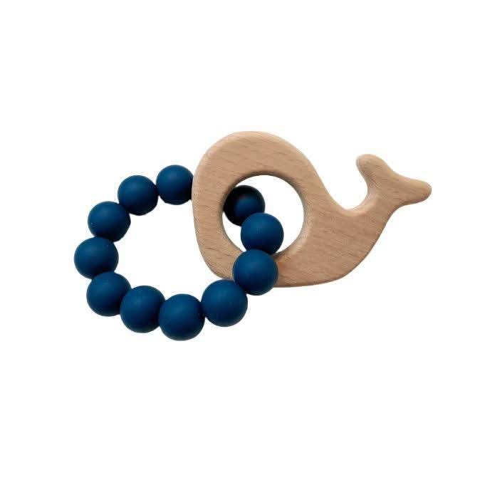 Wooden teething ring with blue beads shaped like a whale on a white background