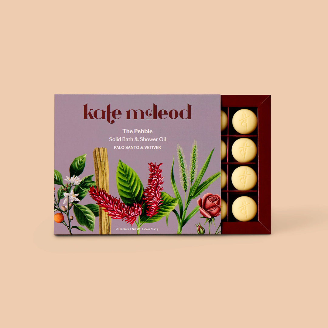 Kate McLeod Palo Santo &amp; Vetiver Pebble solid bath and shower oil on a lavender tray
