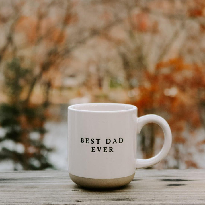 Stoneware mug with 'Best Dad Ever' text on wooden surface outdoors