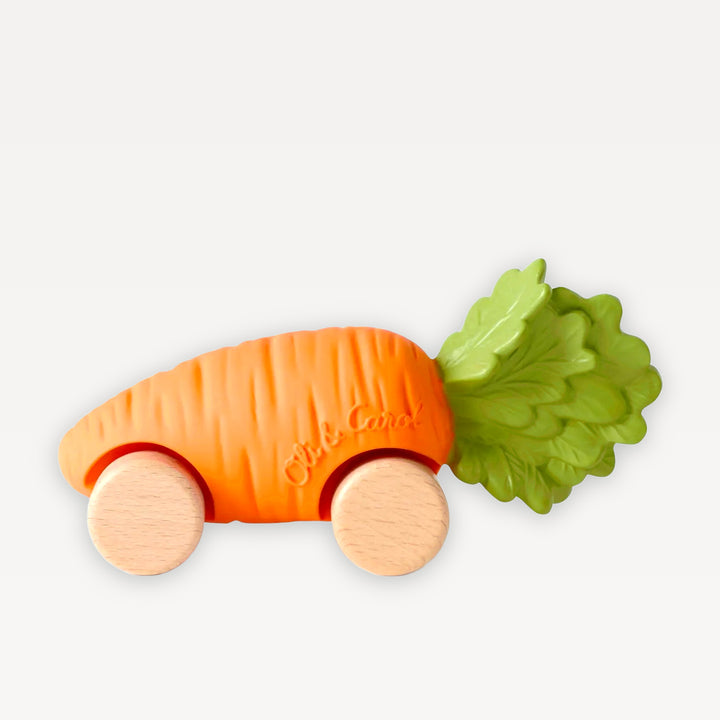 Cathy the Carrot Baby Car by Oli &amp; Carol: orange natural rubber carrot with green leaf top on four beech wood wheels, on a warm white background